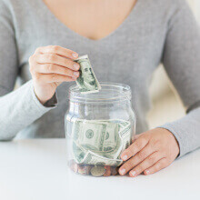 A person giving money full of dollars to another person